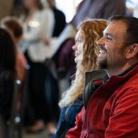 Guests laughing at a speaker at the Lynn M. Blue Connection Naming Ceremony